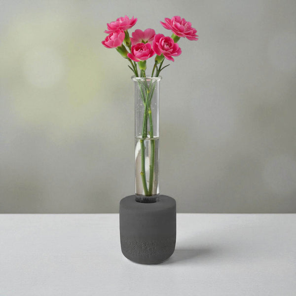 Black round concrete test tube bud vase with pink flowers